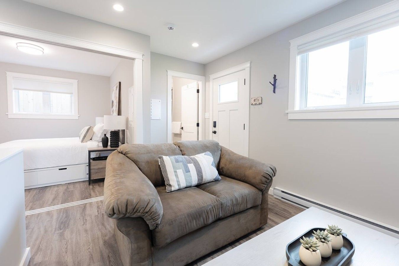 A modern bedroom with a bed, bedside table, and a window.