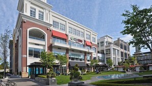 A multi-story building with a prominent clock tower, a central atrium, and a fountain in the courtyard.