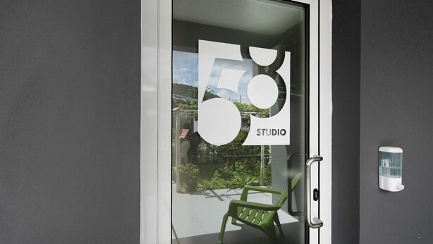 Una puerta con un panel de vidrio que muestra el número 58 y la palabra 'STUDIO'.