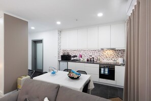A compact kitchen with white cabinets, a microwave, and a sink.