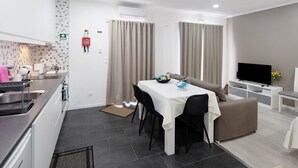 Una cocina moderna con comedor, sofá y televisor.