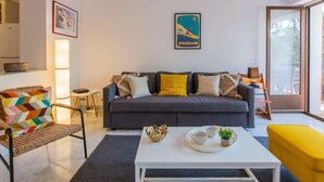 A modern living room with a grey sofa, colorful chair, and a white coffee table. - Le Bourret by Interhome (Hossegor)