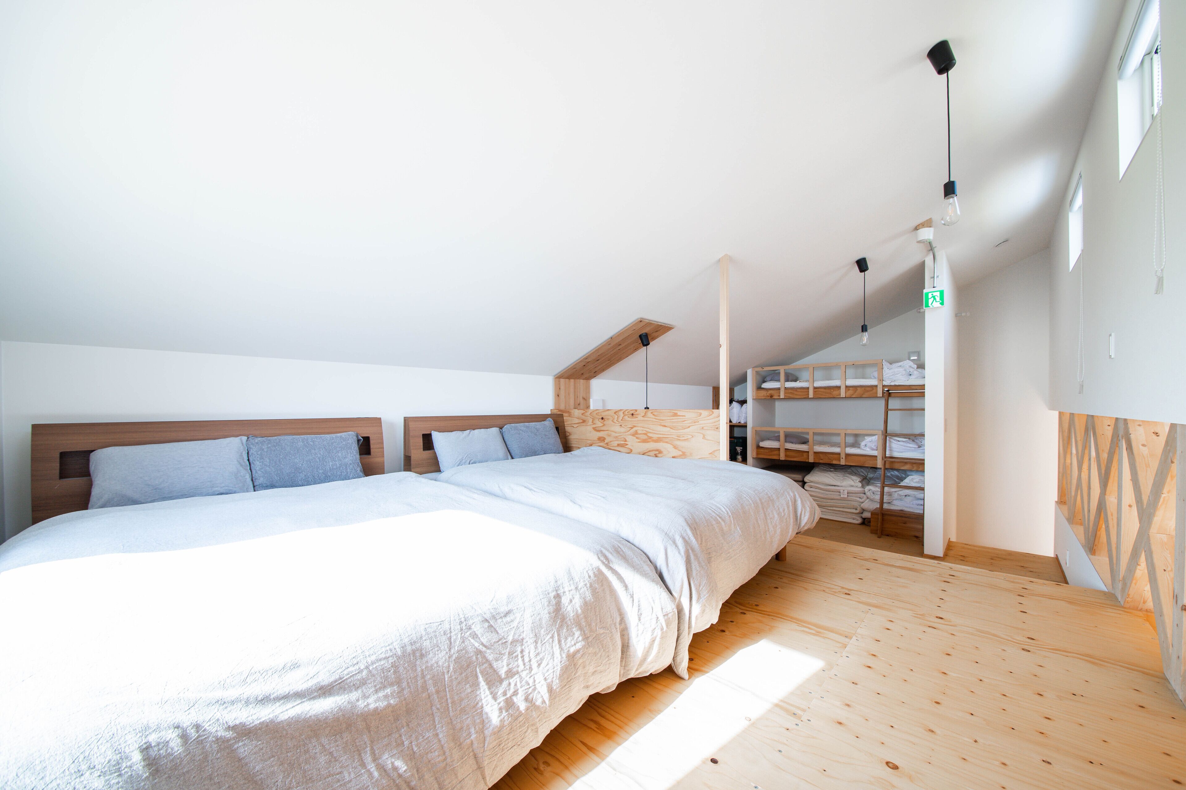 Un dormitorio con una cama grande, suelo de madera y estanterías empotradas.