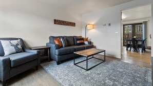 A living room with a sofa, a coffee table, a side table, and a lamp.
