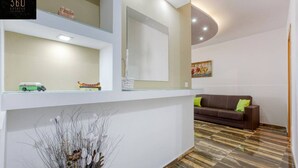 A modern reception area with a sofa, a glass display case, and a decorative plant. - Central 4BR, massive APT with private POOL & BBQ (Is-Swieqi)
