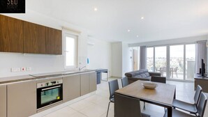 A modern apartment with a kitchen, dining area, and a balcony with a city view. - Beautiful, stunning 3BR home, opposite the harbour (Tal-Pietà)