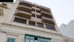 A multi-story building with a green door and windows, a sign for 'ORION', and a 'FOR SALE' sign on the lower left. - Beautiful, stunning 3BR home, opposite the harbour (Tal-Pietà)