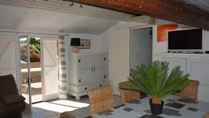 A dining area with a table, chairs, and a fern plant. - Appartement Dans Villa Piscine ET SPA (SAINT LUCIE DE PORTO VECCHIO)