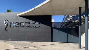 Una entrada moderna de edificio con un cartel que dice "neo residencial mediterráneo".