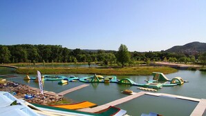 Un parque junto al río con balsas inflables y un muelle de madera.