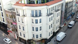 Um hotel de vários andares com telhado plano, janelas amplas e entrada no nível da rua.