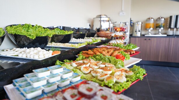 Buffet com diversos alimentos, incluindo ovos, saladas e patês.