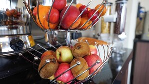 Um quiosque de frutas com maçãs e laranjas.