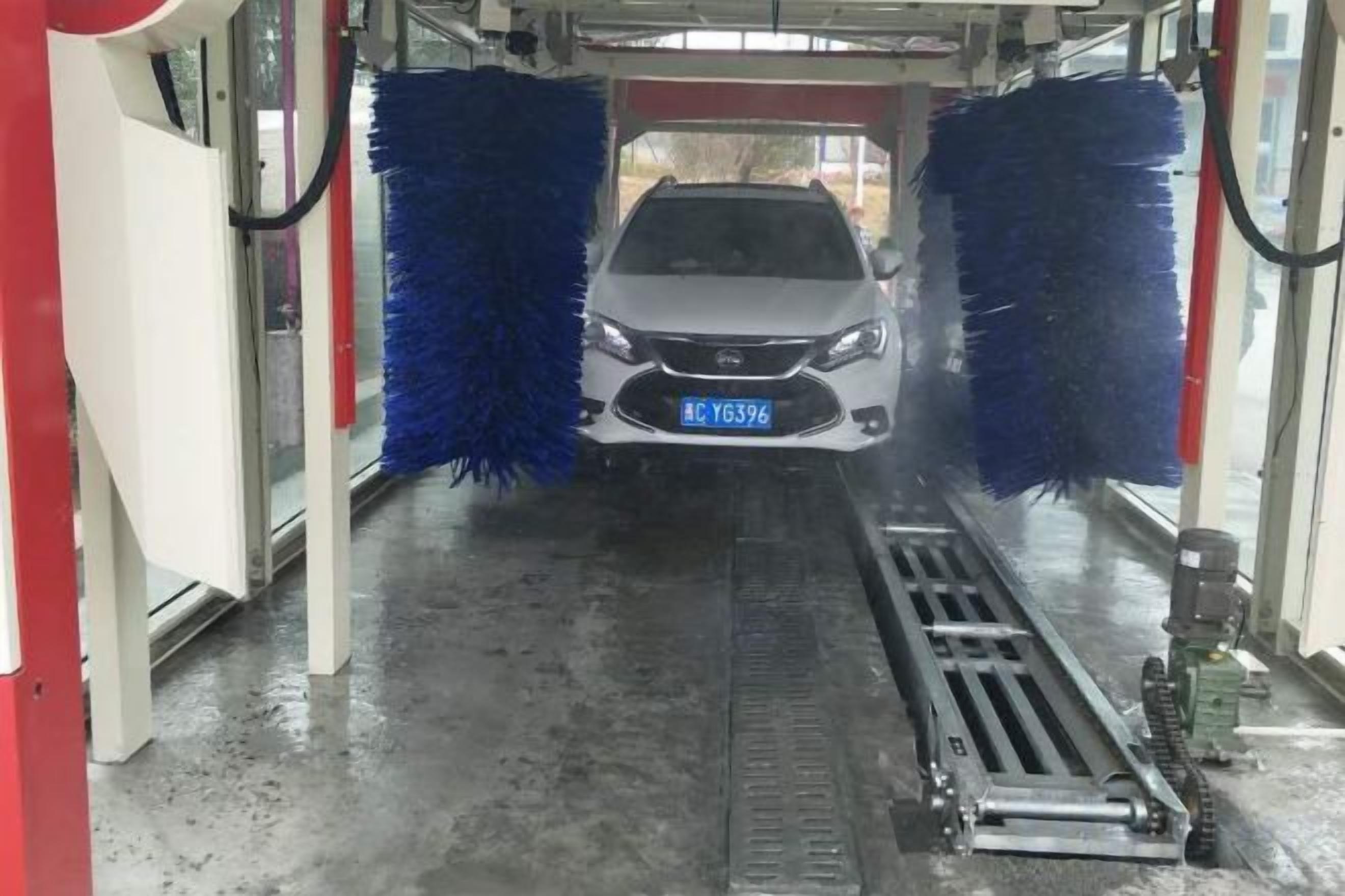 A car in a car wash with blue brushes.