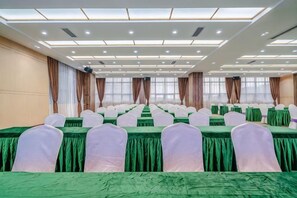 A conference room with rows of tables and chairs, large windows with curtains, and a modern ceiling design. - Bohao Hotel (Zunyi)