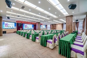 A conference room with rows of tables and chairs, equipped with projectors and screens. - Bohao Hotel (Zunyi)