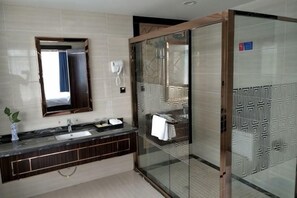 A modern bathroom with a glass-enclosed shower, a large mirror, and a dark wood vanity. - Bohao Hotel (Zunyi)