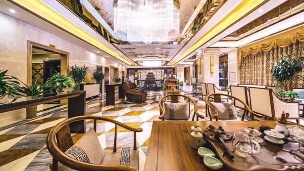A spacious lobby with a checkered floor, comfortable seating, a central staircase, and a chandelier. - Bohao Hotel (Zunyi)
