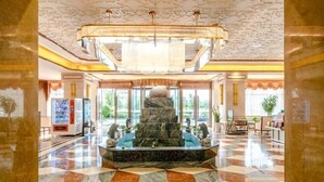 A lobby with a marble fountain, check-in counter, and a vending machine. - Bohao Hotel (Zunyi)