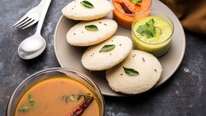 A plate with idlis, a bowl of sambar, and two types of chutneys. - Covie Karle Town 220 (Bengaluru)