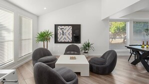A modern living room with a white coffee table, grey sofas, and a framed chessboard on the wall. - Designer Oasis minutes from Scottsdale Events - Heated Pool - Hot Tub - Sleeps 8 (Scottsdale)