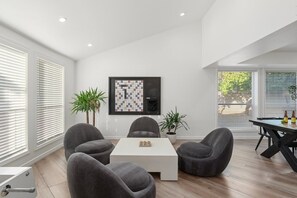 A modern living room with a white coffee table, grey sofas, and a framed chessboard on the wall. - Designer Oasis minutes from Scottsdale Events - Heated Pool - Hot Tub - Sleeps 8 (Scottsdale)