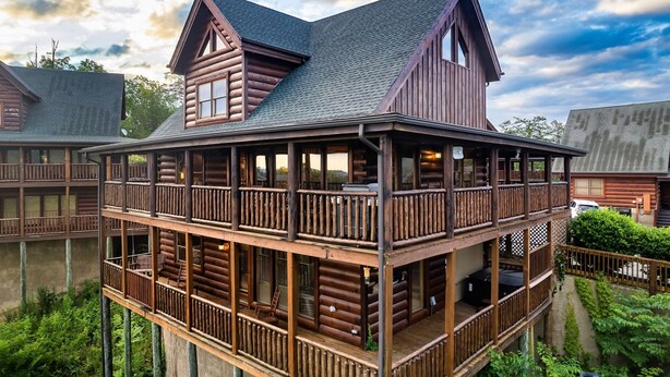 A log cabin with a balcony and a covered porch. - Near Pigeon Forge | Theater, Game Room, Hot Tub & Resort Pools (Sevierville)