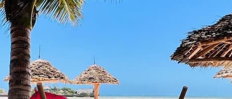 在海滩、白沙、海滩遮阳伞、沙滩毛巾