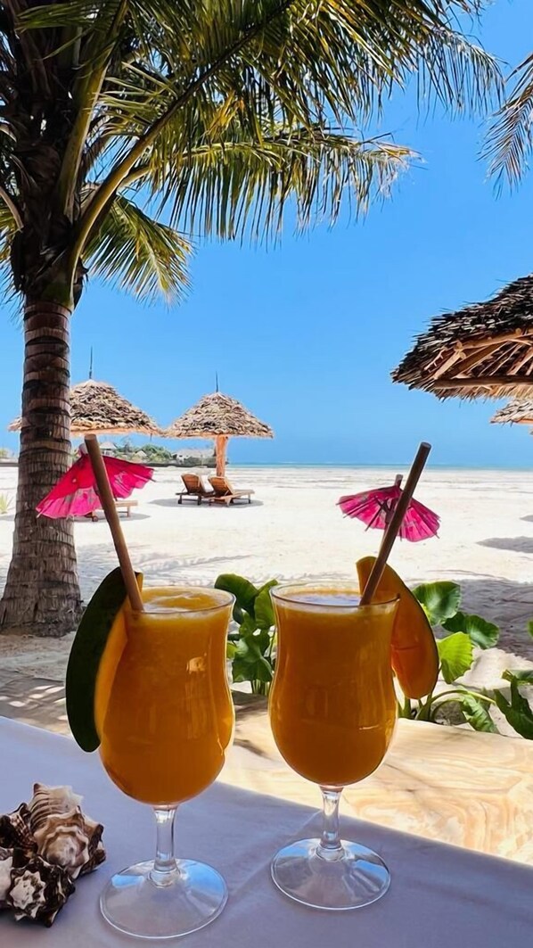 On the beach, white sand, beach umbrellas, beach towels - Karibu beach resort (Pongwe)