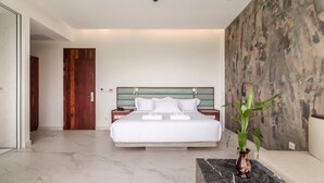 A modern bedroom with a large bed, marble flooring, a green headboard, and a large plant. - Enjoy Boutique Hotel & Restaurat (Siem Reap)