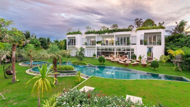 A modern two-story house with a swimming pool, surrounded by lush greenery and palm trees. - Enjoy Boutique Hotel & Restaurat (Siem Reap)