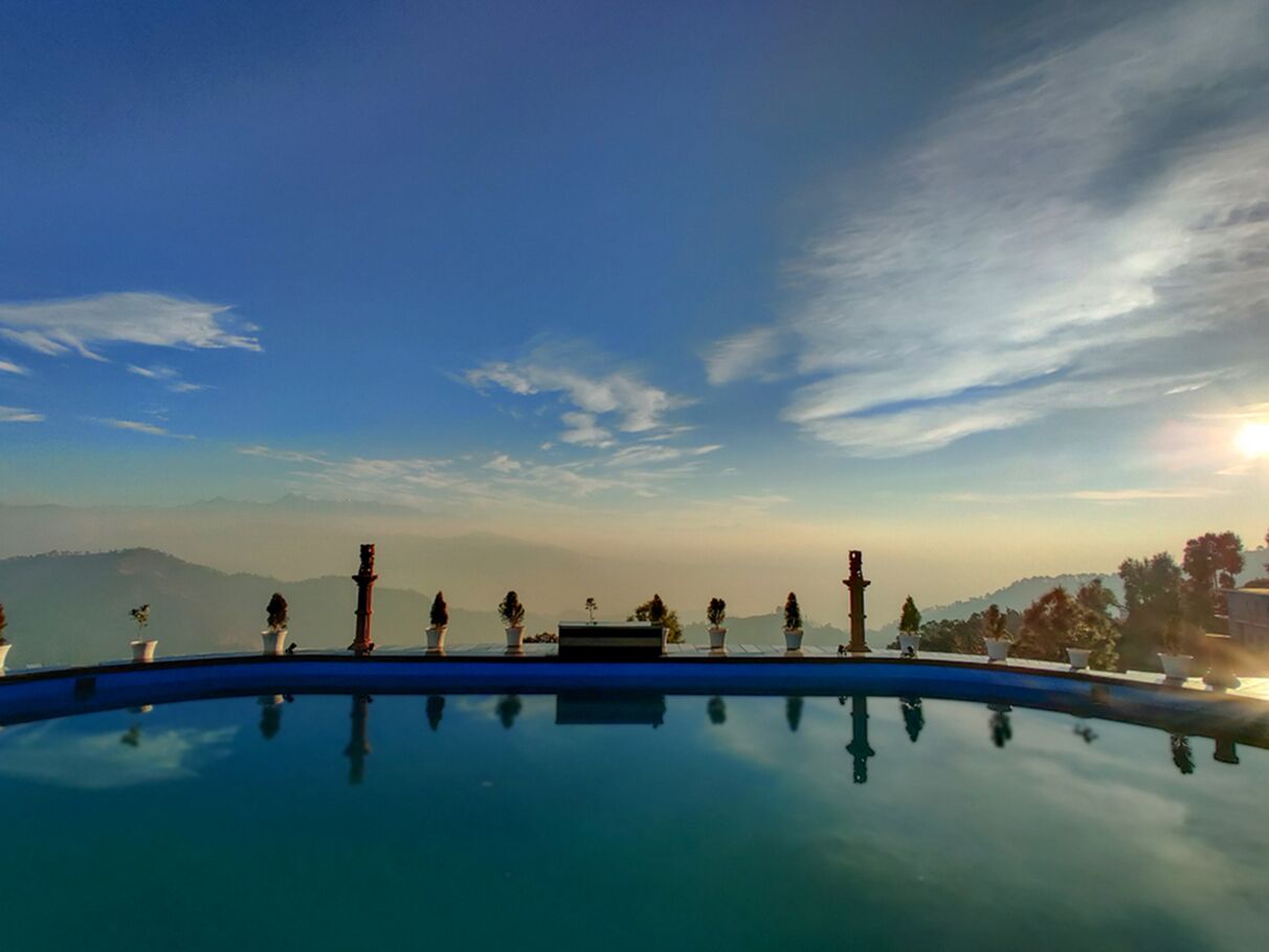 Cielo despejado con una piscina que refleja el entorno.