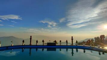 Cielo despejado con una piscina que refleja el entorno.