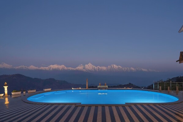A swimming pool with a view of snow-capped mountains in the background.