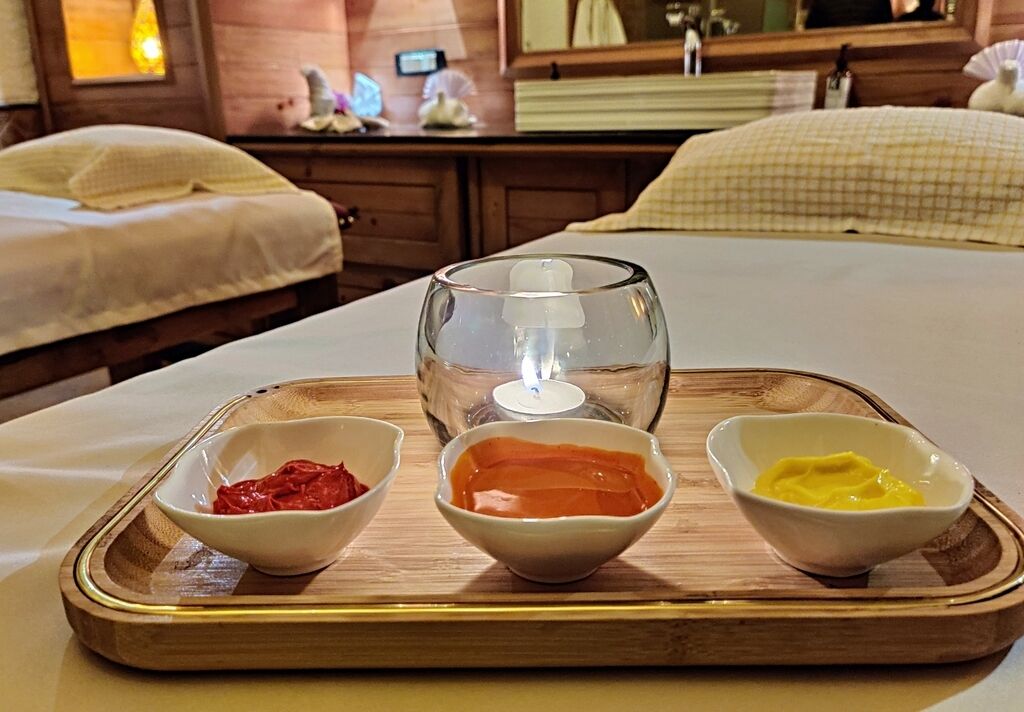 Een dienblad met drie schalen met toevoegingen op een houten tafel in een hotelkamer.
