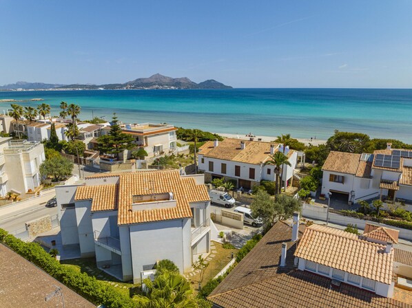 A coastal residential area with houses featuring terracotta roofs and a view of the sea. - Villa Cel (Playa de Muro)