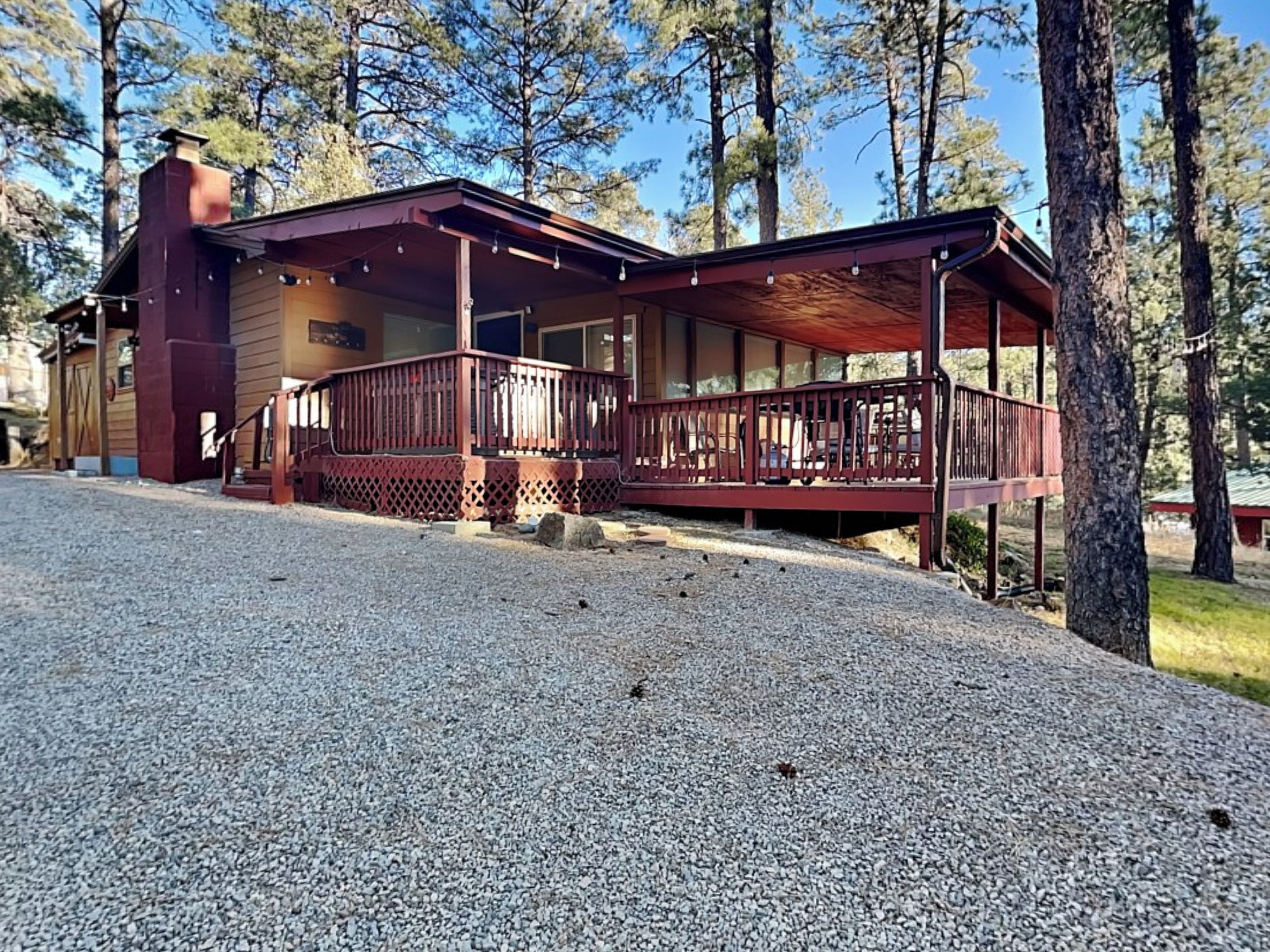 A lodge with a covered porch and a gravel driveway.
