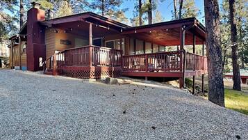 A lodge with a covered porch and a gravel driveway.