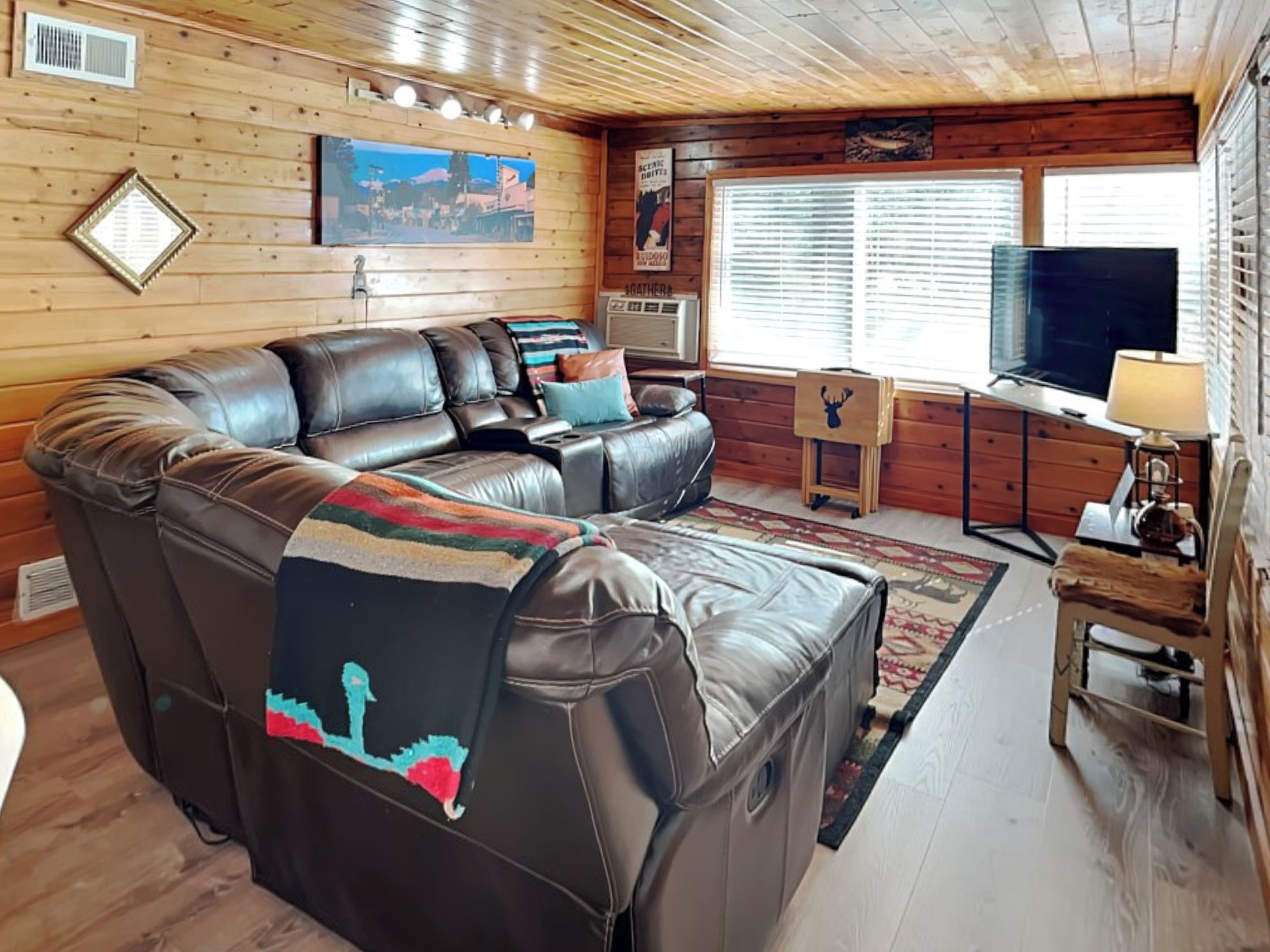 A cozy living room with a large sectional sofa, a television, and a fireplace.