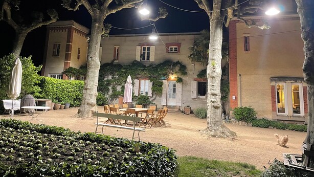 An outdoor courtyard with a dining area, trees, and a building in the background. - Large gîte between Auvergne and Forez heated swimming pool tennis court (Pralong)