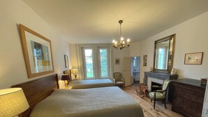 A bedroom with two beds, a chandelier, a dresser, and a mirror. - Large gîte between Auvergne and Forez heated swimming pool tennis court (Pralong)