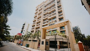 Un hôtel à plusieurs étages, doté d’une porte d’entrée imposante, de balcons à chaque étage et offrant une vue sur un ciel dégagé.