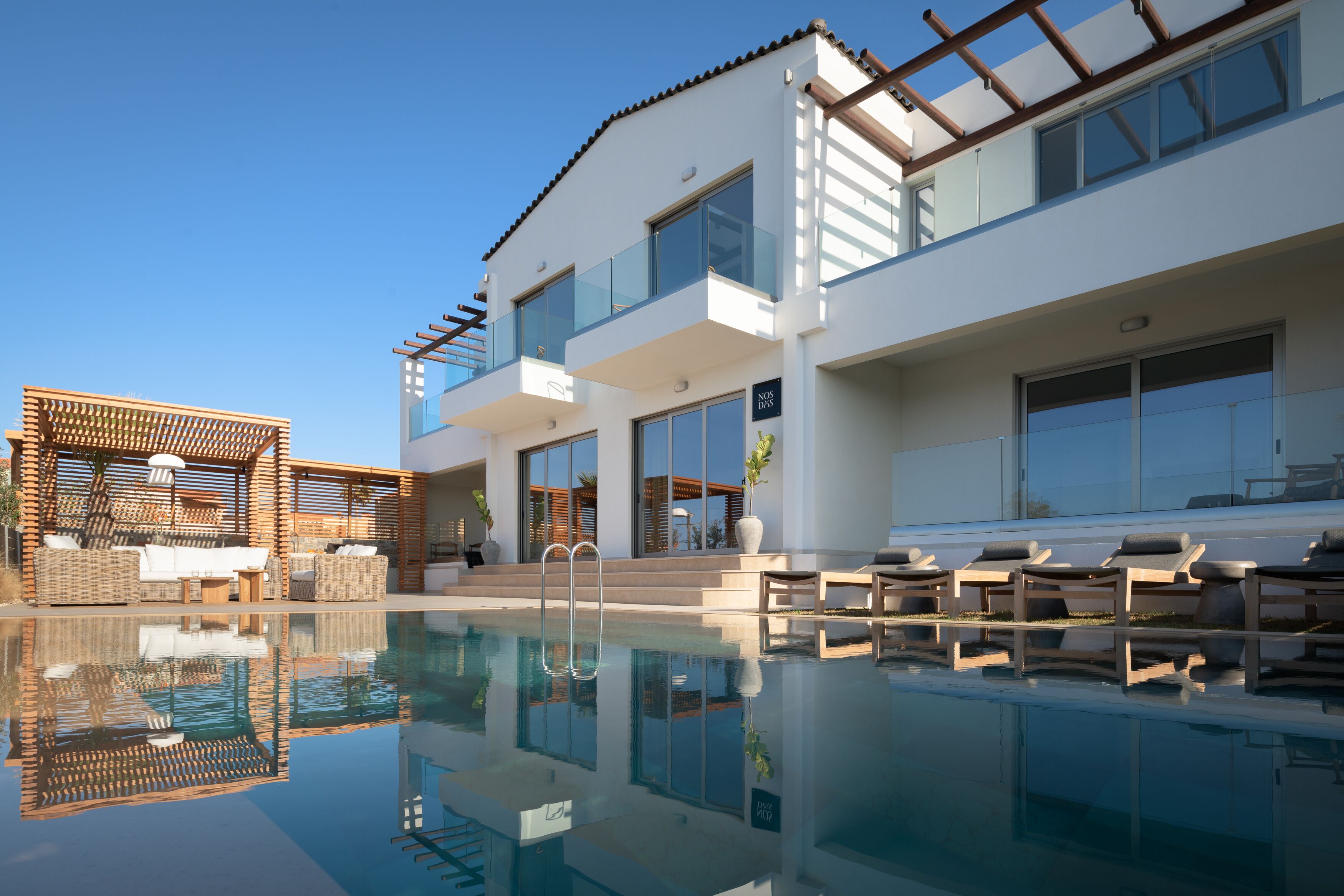 Ein modernes Hotel mit Pool, Außenbereich und großen Fenstern.