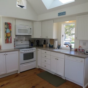 Enjoy cooking in this well-equipped kitchen with a central island, microwave, stove, oven, and dishwasher.