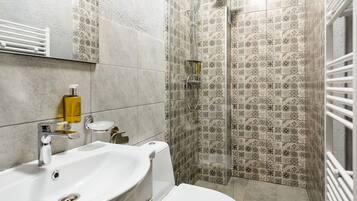 A bathroom with a sink, toilet, and shower.