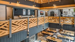 A multi-level restaurant with wooden railings, tables, and chairs.