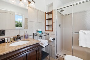 Une salle de bain avec deux lavabos, une douche et une fenêtre.