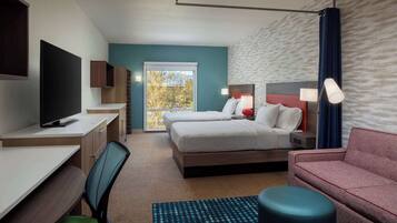 Suite estudio, 2 camas de matrimonio | Zona de estar | Televisión de pantalla plana de 55 pulgadas con canales por satélite