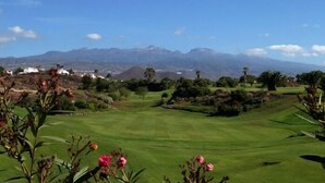 Un campo da golf con vista panoramica sulle montagne sullo sfondo.