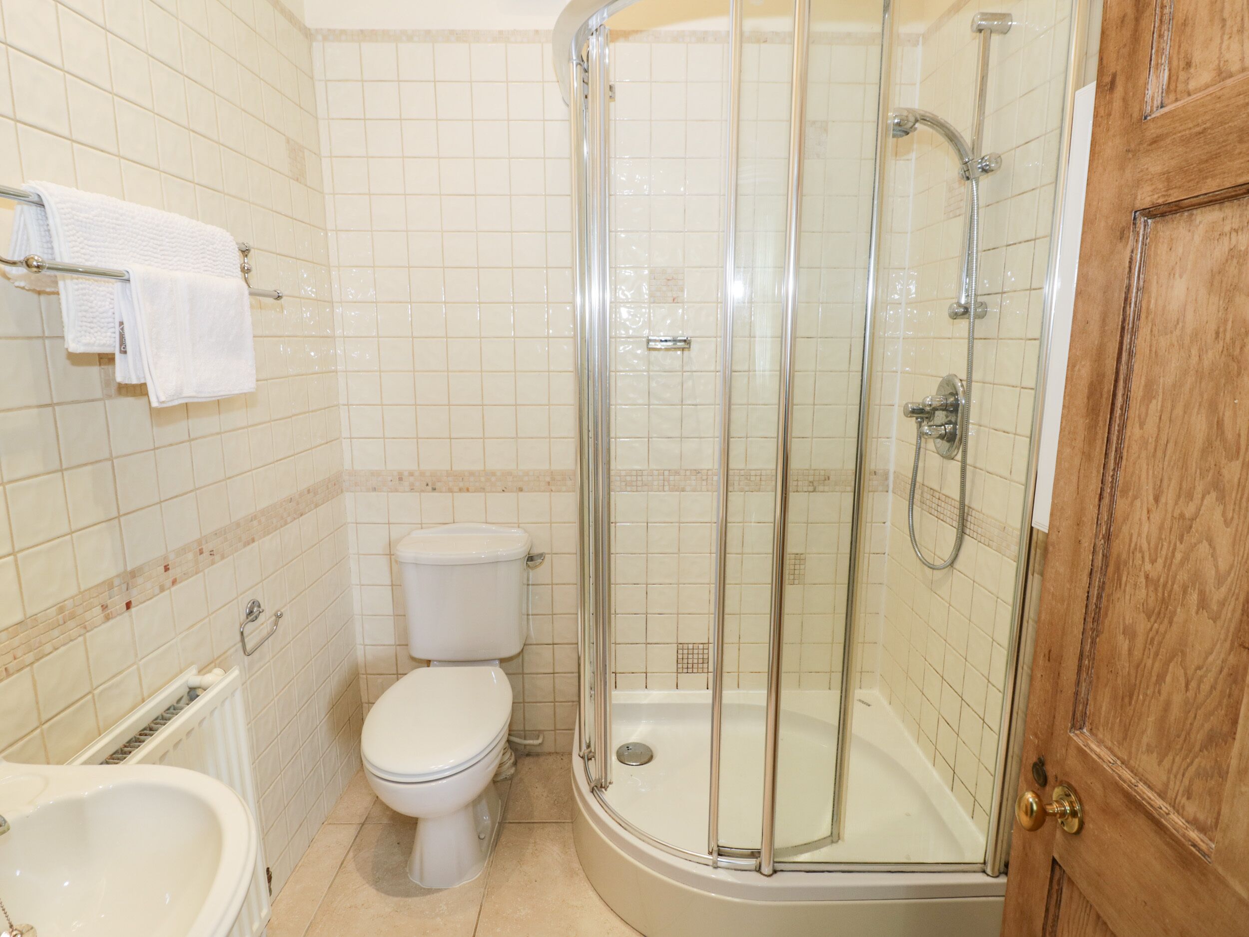 Een badkamer met toilet, bidet en een douchecabine met glazen wanden.